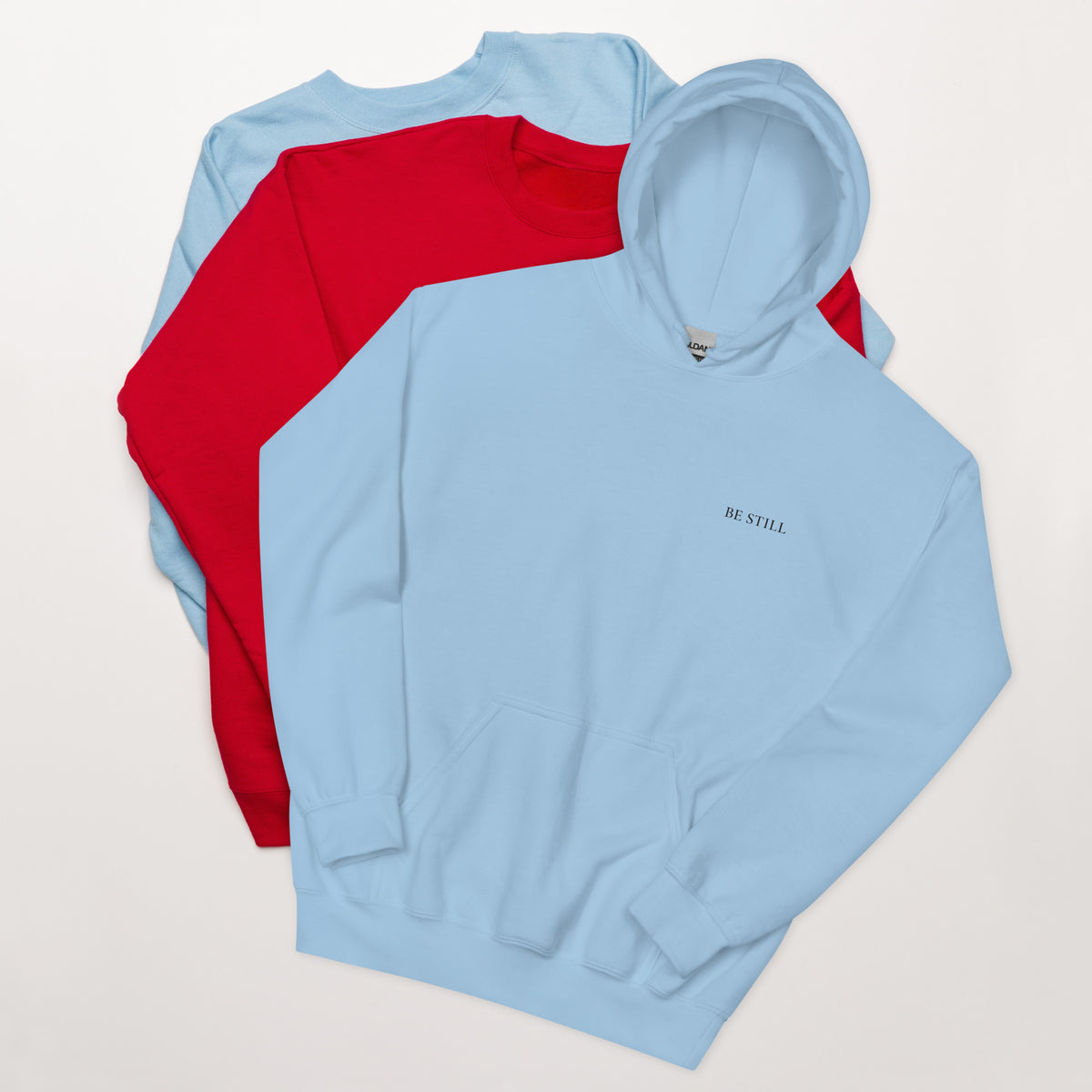 Light blue heavy blend fleece hoodie with small chest BE STILL quote, front detail