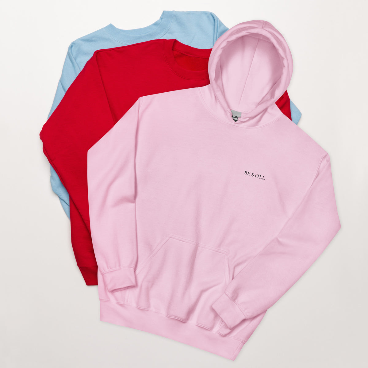 Light pink heavy blend fleece hoodie with small chest BE STILL quote, front detail